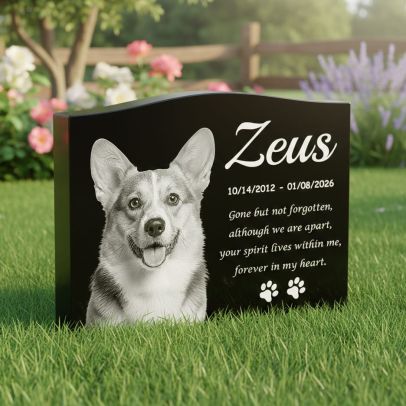 Polished serpentine top black granite dog memorial stone with custom photo engraving placed on garden lawn