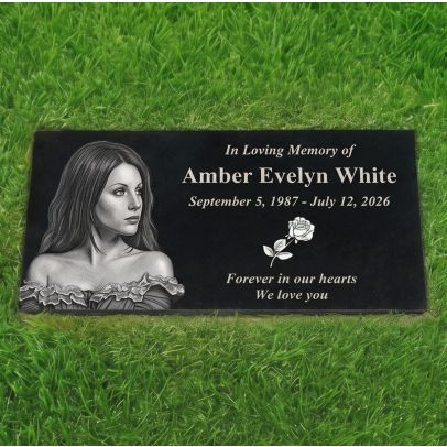 Personalized black granite photo memorial stone laid on green grass